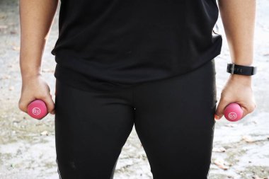 Dambıl egzersizi yapan kadın.