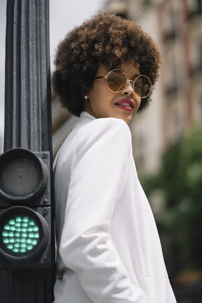 Afro haired woman poses through the streets of Madrid Spain.