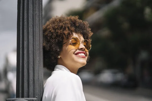 Afro haired woman poses through the streets of Madrid Spain.