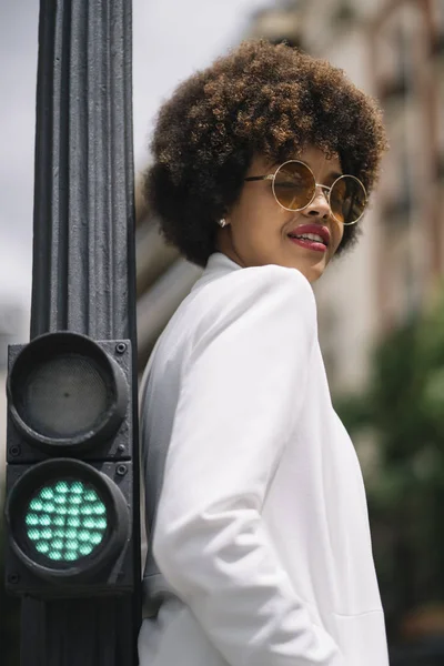 Afro haired woman poses through the streets of Madrid Spain.