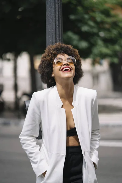 Afro haired woman poses through the streets of Madrid Spain.