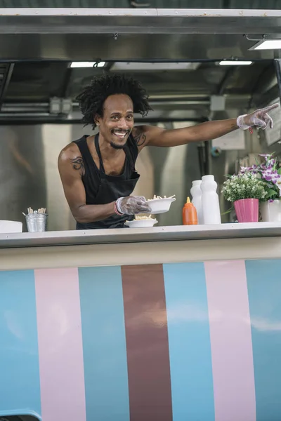 African American man serves food in van