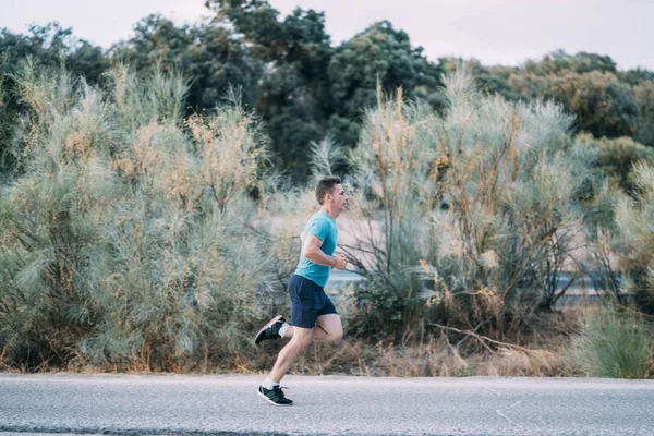 Classic vintage man does sport and runs in the field.