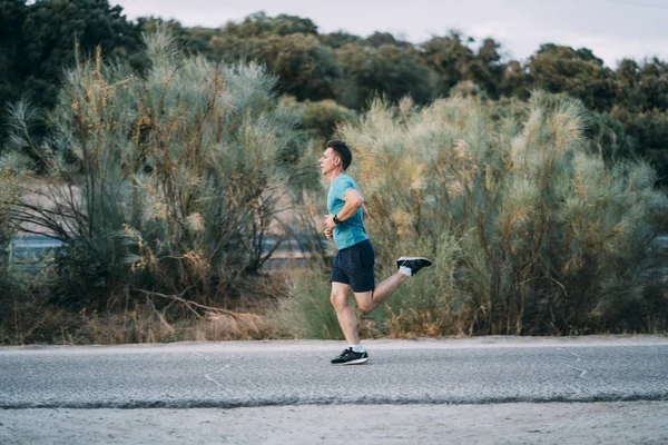 Classic vintage man does sport and runs in the field.