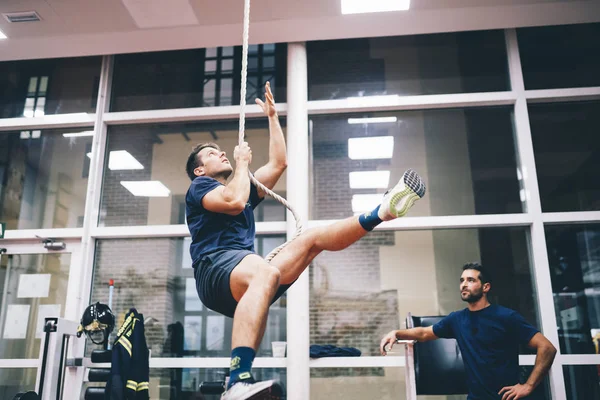 Fireman training hard at the station with a rope.