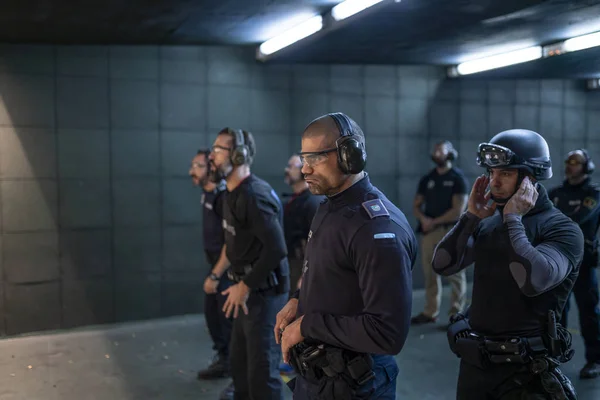 Police training in shooting gallery with short weapon.