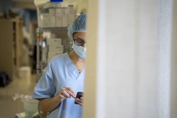 Female surgeon doctor consults the mobile phone before operation.