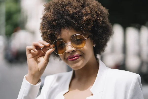 Afro haired woman poses through the streets of Madrid Spain.