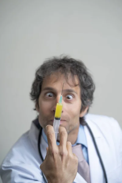 Portrait of crazy doctor with a syringe