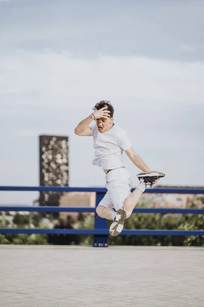 Latin man dancing break dance on a road.