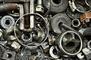 Portre, kirli pas cıvata ve somun yağ lekeleri ile kaplı bir alan üzerinde yerleştirilir. Yatay renkli görüntü.