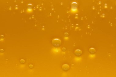 Sarı arka planda altın su damlaları. Bir metin için kopyalama alanı olan yaratıcı afiş tasarımı için. Seçici odak