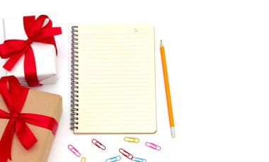 top view Gift box with notepad,pencil yellow,paper clip placed on the desk isolated on white background