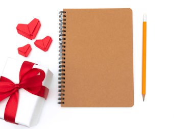 üstten görünüm hediye kutusu ile not etmek, kalp, kalem sarı beyaz arka plan üzerinde izole masa üzerine yerleştirilen