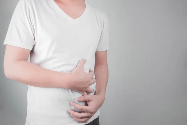 アジア系の若い男性は 胃潰瘍から苦しんでいます ピロリ菌健康問題概念の感染によって胃炎が発生しました — ストック写真