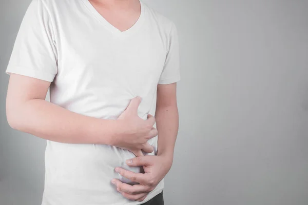 Asian Young men are suffering from stomach ulcers. gastritis Caused by the infection of H. pylori bacteria  healthcare and health problem concept