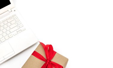 çalışma alanı en iyi Görünümü Kapat nesneleri beyaz hediye kutusu papyon kırmızı kurdele ve dizüstü bilgisayar üzerinde beyaz izole arka plan neşeli Noel ve mutlu yeni yıl kavramı