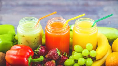 taze sıkılmış meyve suyu, smoothies sarı turuncu yeşil mavi muz limon elma portakal kivi üzüm kadar yakın bir koyu ahşap zemin üzerinde çilek.