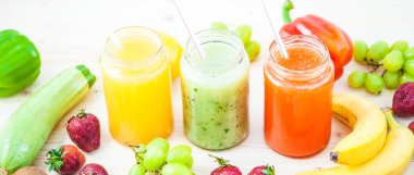 taze sıkılmış meyve suyu, smoothies sarı turuncu yeşil mavi muz limon elma portakal kivi üzüm koyu ahşap arka plan üzerinde kopya alanı düz çilek afiş kavramı yatıyordu.