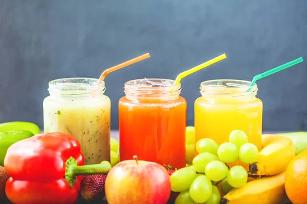 taze sıkılmış meyve suyu, smoothies sarı turuncu yeşil mavi muz limon elma portakal kivi üzüm çilek koyu ahşap arka plan kopya alanı üzerinde.