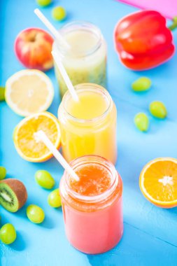 taze sıkılmış meyve suyu, smoothies sarı turuncu yeşil mavi muz limon elma portakal kivi üzüm kadar parlak mavi zemin üzerine yakın çilek.