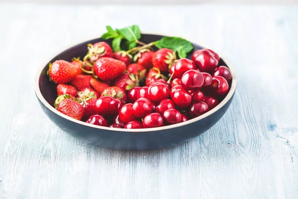 Kiraz, çilek ve nane ile siyah plaka. Yaz konsepti. Kopya alanı