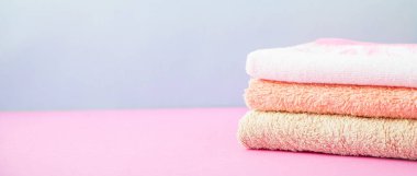 banyo aksesuarları - havlu katlanmış, kendiniz için vücut bakım kavramının bir ışık, parlak mavi ve pembe arka plan üzerine yığılmış. Kopya alanı afiş