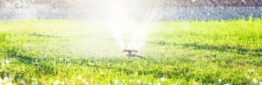 yeşil çim su sıçramalarına. Sulama sistemi arka plan, banner