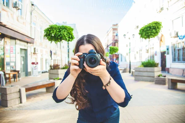 Kamera ve fotoğrafçı yakın çekim ile sokakta yürürken güzel kadın turist