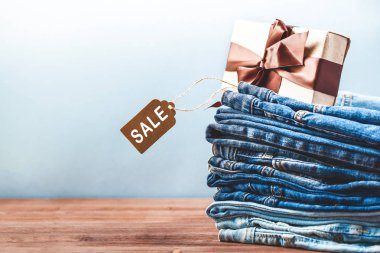 Siyah Cuma etiketi, mavi kot pantolon ve hediye boşaltmak Satılık söylüyor hafif bir arka plan ile konsept satış, iskontoları