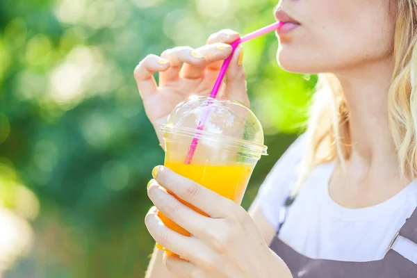 a girl drinks freshly squeezed juice, a healthy lifestyle.