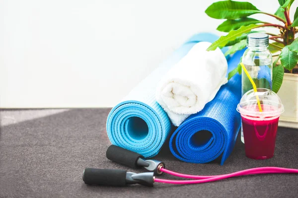 set for sports, a yoga mat, a towel, smoothies, jumping rope, a bottle of water. The concept of a healthy lifestyle Copy space