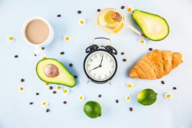 sabah kahve Kupası'nda bir beyaz kruvasan avokado uyanış bir çalar saat kahvaltı neşe, sağlıklı kahvaltı tazelik ile