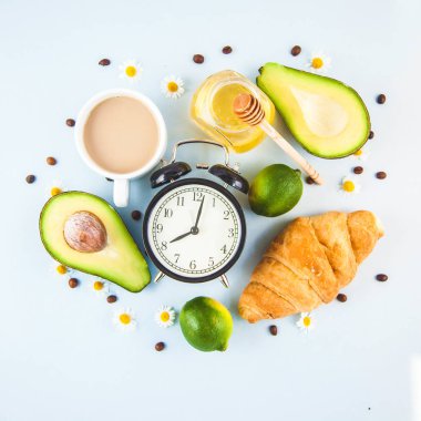 sabah kahvaltı, kahve Kupası'nda bir beyaz kruvasan avokado uyanış neşeli, sağlıklı bir çalar saat ile kahvaltı taze kopya alanı