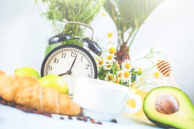sabah kahve Kupası'nda bir beyaz kruvasan avokado uyanış bir çalar saat kahvaltı neşe, sağlıklı kahvaltı tazelik ile