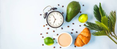 sabah kahvaltı, kahve Kupası'nda bir beyaz kruvasan avokado kireç uyanış neşeli, sağlıklı bir çalar saat ile kahvaltı taze kopya alanı üstten görünüm