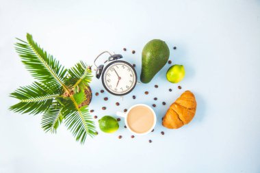 sabah kahvaltı, kahve Kupası'nda bir beyaz kruvasan avokado kireç uyanış neşeli, sağlıklı bir çalar saat ile kahvaltı taze kopya alanı üstten görünüm.