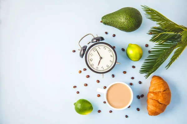 sabah kahvesi bir çalar saat kahvaltı neşe ile hafif bir arka plan uyandırma üzerinde beyaz bir fincan kruvasan avokado kireç, sağlıklı kahvaltı tazelik düz kopya spase yatıyordu..