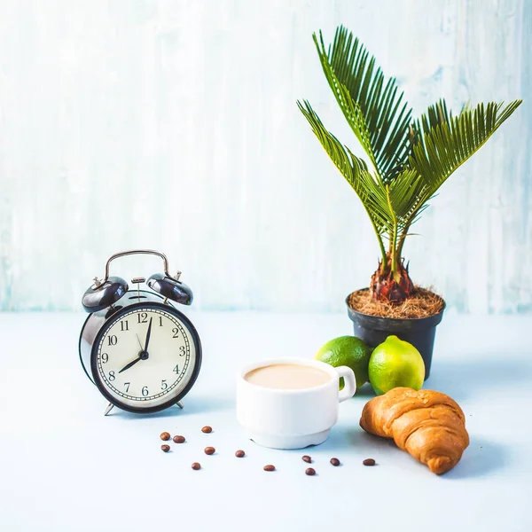 sabah kahvaltı, kahve ateşin üzerinde beyaz bir fincan kruvasan avokado kireç uyanış bir çalar saat neşeli, sağlıklı kahvaltı taze kopya alanı ile arka plan