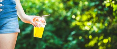 Genç güzel kız sulu yeşillik Banner arka plan üzerinde taze sıkılmış meyve suyu içecekler