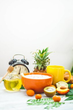 sabah kahvaltı, müsli, meyve, şeftali, bal ve ananas yeşil ışık bir zemin üzerine bırakır uyanış bir çalar saat ile sağlıklı kahvaltı tazelik kopya alanı