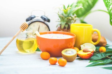 sabah kahve kahvaltı müsli, meyve, şeftali, bal ve ananas yeşil ışık bir zemin üzerine bırakır uyanış bir çalar saat ile sağlıklı kahvaltı tazelik yakın çekim