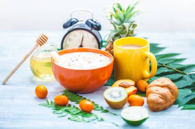 sabah kahvaltı, müsli, meyve, şeftali, bal ve ananas yeşil ışık bir zemin üzerine bırakır uyanış bir çalar saat ile sağlıklı kahvaltı tazelik boşaltmak