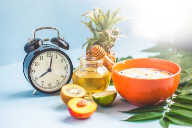 sabah kahve kahvaltı müsli, meyve, şeftali, bal ve ananas yeşil ışık bir zemin üzerine bırakır uyanış bir çalar saat ile sağlıklı kahvaltı tazelik yakın çekim