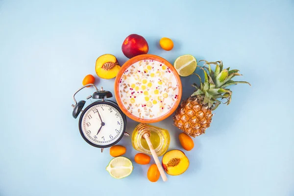 sabah kahvaltı, müsli, meyve, şeftali, ananas, tatlım üstten görünüm kopya alanı uyanış bir çalar saat sağlıklı kahvaltı tazelik düz ile mavi bir arka plan üzerinde yatıyordu