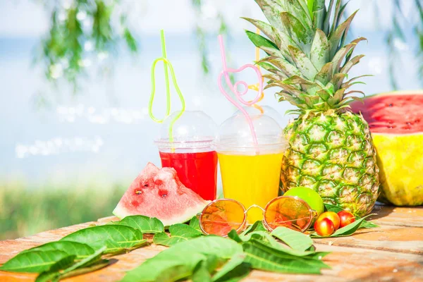 Parlak taze sağlıklı meyve suları, meyve, ananas, karpuz deniz arka plan üzerinde. Summer, dinlenme, sağlıklı yaşam tarzı kopya alanı