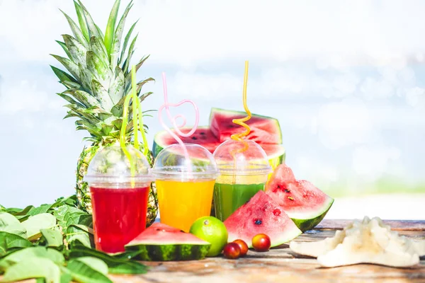 Parlak taze sağlıklı meyve suları, meyve, ananas, karpuz deniz arka plan üzerinde. Summer, dinlenme, sağlıklı yaşam tarzı kopya alanı