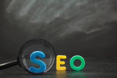 SEO arama motoru optimizasyonu kavramı SEO renk harflerle Büyüteç siyah bir arka plan kopya alanı