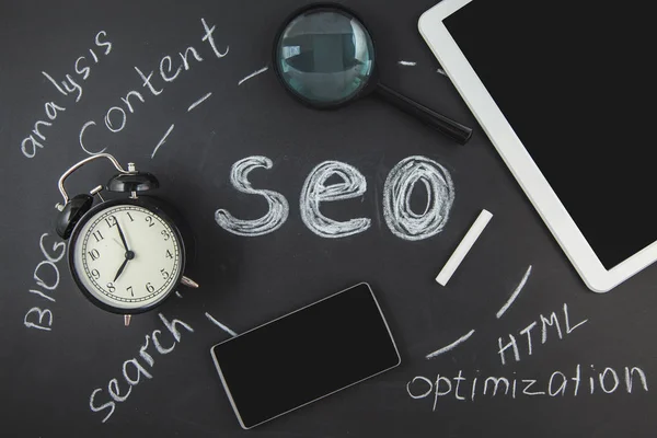 SEO arama motoru optimizasyonu kavramı Büyüteç Camı'nı, saat, siyah bir arka plan ile bir yazıt Seo Closeup smartphone