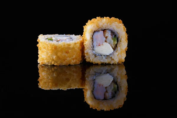 appetizing baked sushi roll with fish on a black background with reflection Menu and restaurant concept Copy space